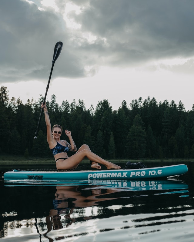 femme se mettant en place pour faire du yoga sur son paddle