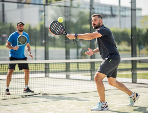 Deux hommes amateurs de padel en double se préparent pour un service sur un terrain vitré, dans une ambiance lumineuse et réaliste.
